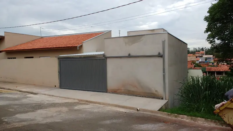 Portão metálico cinza instalado em garagem residencial